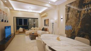 Una sala de estar con un sofá, una mesa y un televisor. en Nile Luxury Appartment, en El Cairo