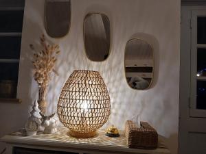 een kamer met een tafel met een lamp en spiegels bij L'écrin de la Pinède in La Barre-de-Monts