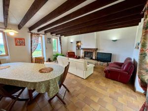 Grande Maison au Calme في La Merlatière: غرفة معيشة مع طاولة ومدفأة