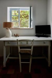 een bureau met een monitor, een lamp en een stoel bij L'écrin de la Pinède in La Barre-de-Monts