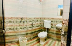 un baño con inodoro y lavabo en Shree Kesar Inn, en Udaipur
