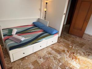 een wit bed met blauwe kussens erop bij Casa Vacanze Terramare in Bogliasco +29 foto's