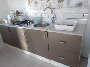 a small kitchen with a sink and a stove at CoCo de Mer Self Catering Log 1 in Lambertʼs Bay