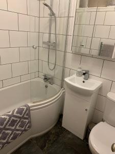 a bathroom with a tub and a sink and a toilet at Dog Friendly Apartment with Sea Views in Ryde