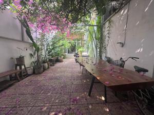 a patio with a wooden table with flowers on it at Notre Maison 5 - R07 in Ho Chi Minh City