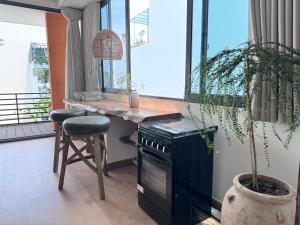 a kitchen with a stove and a stool and a window at Notre Maison 5 - R07 in Ho Chi Minh City