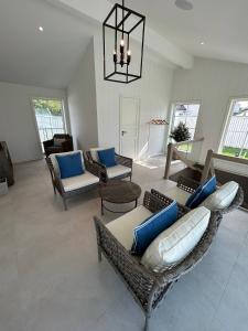 een woonkamer met een bank, stoelen en een kroonluchter bij Sjøgata Hagehus in Larvik