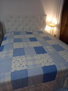 a bed with a blue and white quilt on it at Rheinapartment 8 in Bad Hönningen