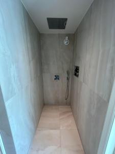 a bathroom with a shower with a phone on the wall at Sjøgata Hagehus in Larvik