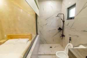 a bathroom with a shower and a toilet and a sink at Homestay Cô Hai in Xóm Rạch Già