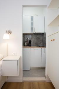 a white kitchen with white cabinets and a sink at Orsan Residence Apartment in Dubrovnik