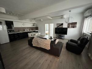 a living room with a couch and a kitchen at Sentral fantastisk leilighet in Øvre Årdal