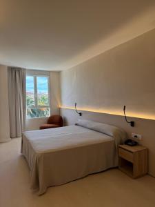a bedroom with a bed and a chair and a window at El Globo in Valencia +215 photos