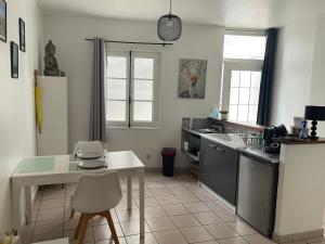 a kitchen with a table and a white counter top at Appartement centre historique Sancerre in Sancerre