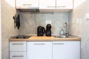 a kitchen with white cabinets and a sink at Orsan Residence Apartment in Dubrovnik +81 photos