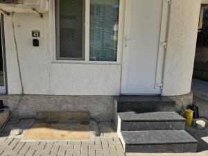 a front door of a house with stairs and a window at Студио за гости на град Бургас in Burgas City