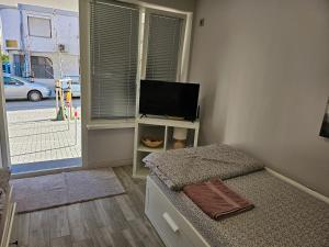 a bedroom with a bed and a flat screen tv at Студио за гости на град Бургас in Burgas City