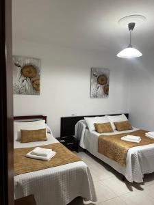 a bedroom with two beds with towels on them at Pensión Bodega de Ana in San Ciprián