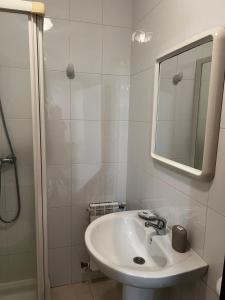 a white bathroom with a sink and a mirror at Pensión Bodega de Ana in San Ciprián