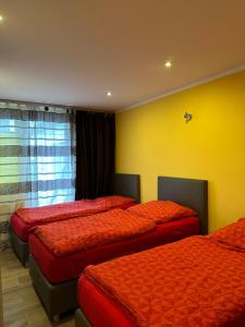a bedroom with two beds and a yellow wall at CASA Del SUR in Braunschweig