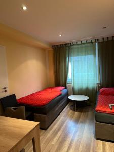 a small room with two beds and a table at CASA Del SUR in Braunschweig