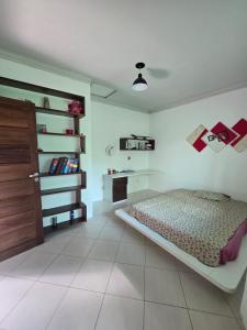 - une chambre avec un lit et une porte en bois dans l'établissement RSF itapua, à Salvador