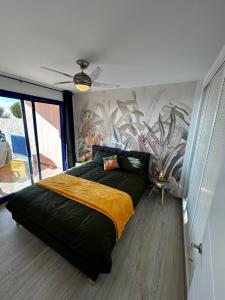 a bedroom with a large bed with a painting on the wall at Mojacar Playa Atalaya Résidence in Mojácar