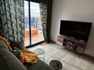 a living room with a couch and a flat screen tv at Mojacar Playa Atalaya Résidence in Mojácar