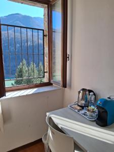 a table with a tea kettle and a window at Il vecchio convento in Vagli di Sotto