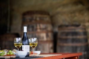 a bottle of wine and two wine glasses on a table at Quinta Pousada de Fora Wines & Tourism in Guimarães