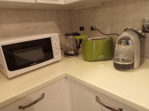 a kitchen counter with a microwave and a toaster at Casarosa in Porretta Terme