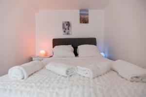 a large bed with white sheets and pillows at Charmant appartement à Groslay in Groslay