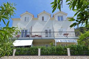 a large white house with a balcony at Apartments Mićić in Hvar