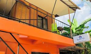 ein orangefarbener Balkon an einem Gebäude mit einem Schild darauf in der Unterkunft Wakims Budget Fan Room in Coron