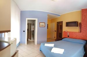 a bedroom with a blue bed and a bathroom at La Lanterna in Silvi Marina