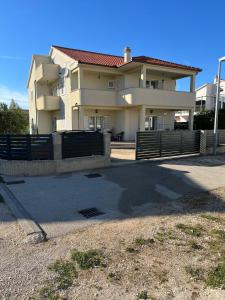 a large house with a fence in front of it at Apartments Vido in Vodice