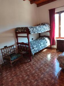 a room with two bunk beds and a chair at Hospedaje Familiar Tilcara Monoambiente in Tilcara
