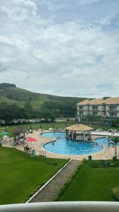 a large swimming pool with people in a resort at Flat Village - Aldeia das Águas D301 in Barra do Piraí
