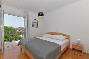 a bedroom with a bed and a large window at Apartments Mićić in Hvar