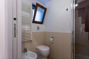 a bathroom with a toilet and a sink and a window at 100 Mq, Free Parking, Charming House Ponte Coperto in Pavia +11 photos