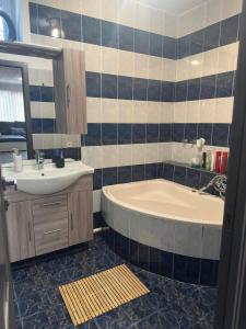 a bathroom with a tub and a sink at BÉTA Apartman in Sárospatak