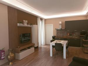 a small living room with a table and a kitchen at Borgese Apartments in Palermo