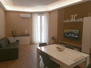 a living room with a table and a couch at Borgese Apartments in Palermo