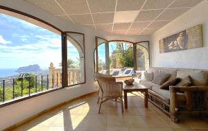 a living room with a couch and large windows at Villa La Mansion in Benissa