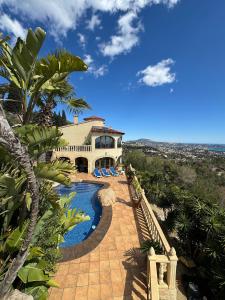 a villa with a swimming pool and a house at Villa La Mansion in Benissa