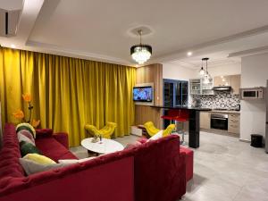 Résidence de Luxe avec Piscine à Costa Mar Playa في مرتيل: غرفة معيشة مع أريكة حمراء وستائر صفراء