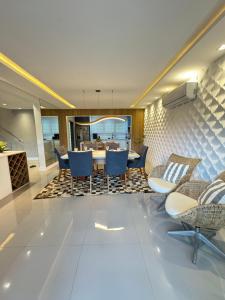 a dining room with blue chairs and a table at Paraiso na Praia da Enseda in Guarujá