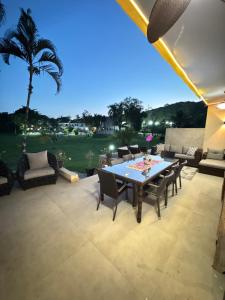 a patio with a table and chairs and a palm tree at Paraiso na Praia da Enseda in Guarujá