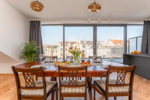 una sala da pranzo con tavolo e sedie e una grande finestra di Visit Oomph Apartments a Praga