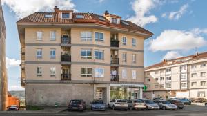 a tall building with cars parked in a parking lot at Vivienda Alló in Rois